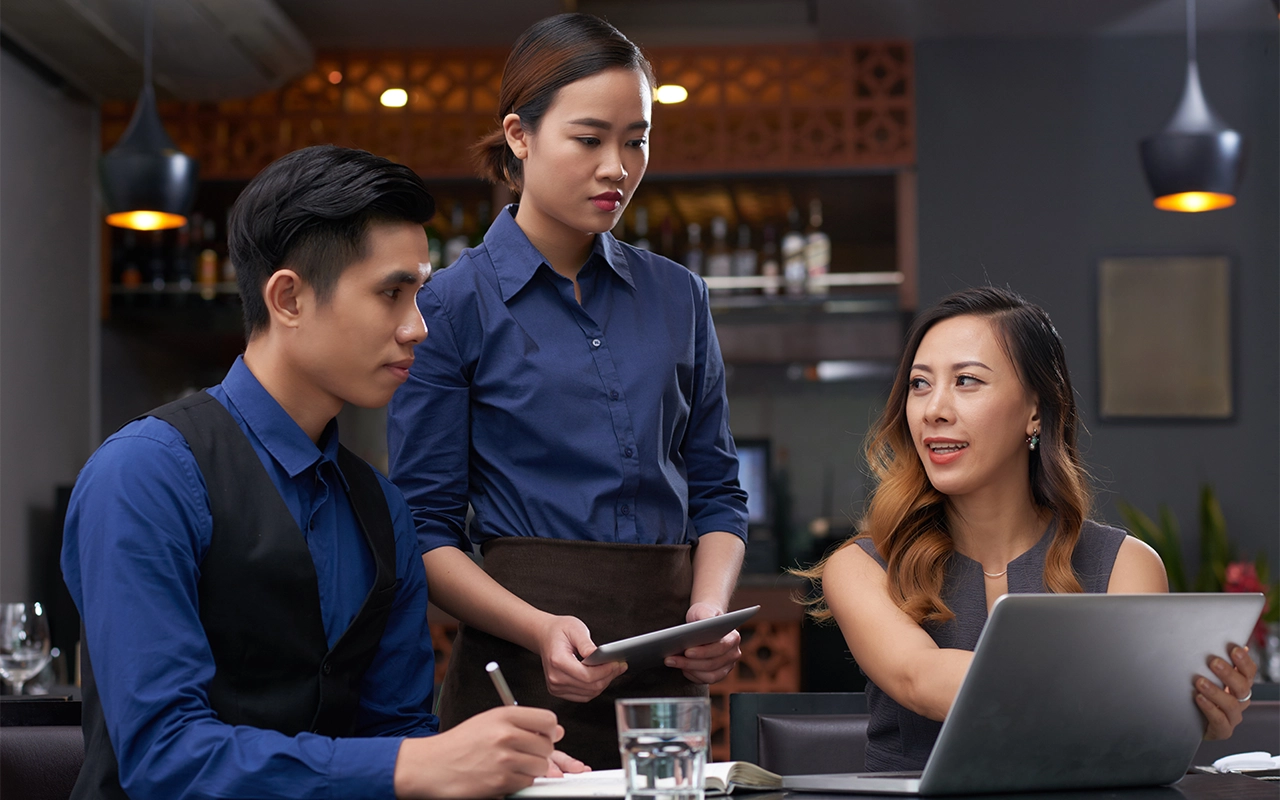 Two employees discussing with a customer on a custom solution requested by the customer.